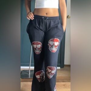 Black with rhinestone skulls embroidered onto the sweatpants + two back pockets